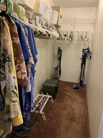 a view of walk in closet with clothes and shoes