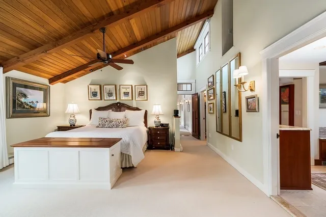 a spacious bedroom with a large bed and a chandelier