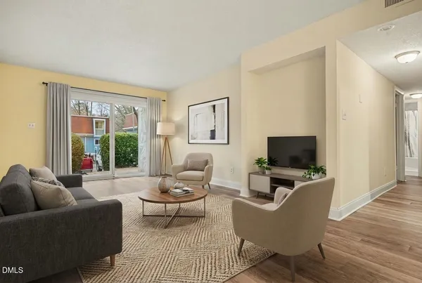 a living room with furniture a flat screen tv and a window