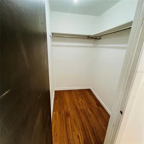a view of a room with wooden floor and a ceiling fan