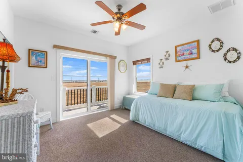 a living room with a balcony furniture a flat screen tv and a window