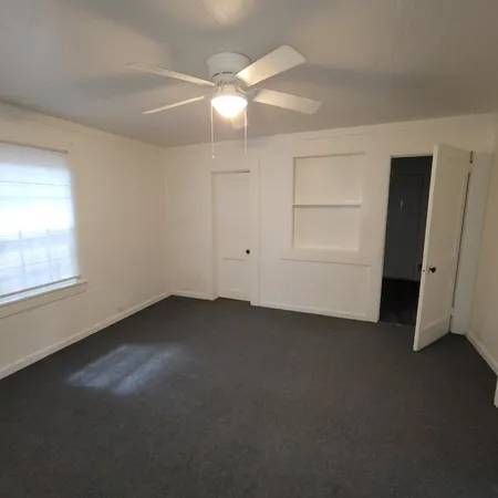 an empty room with windows and closet