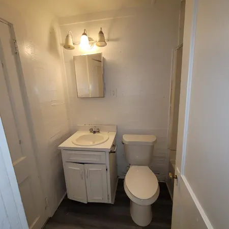 a bathroom with a toilet sink and mirror