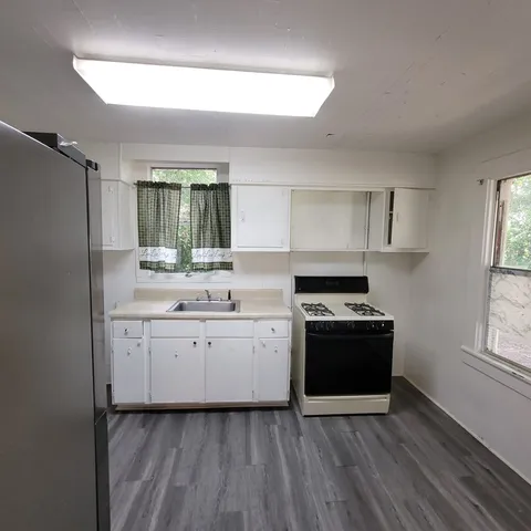 a kitchen with stainless steel appliances granite countertop a stove a sink and a refrigerator