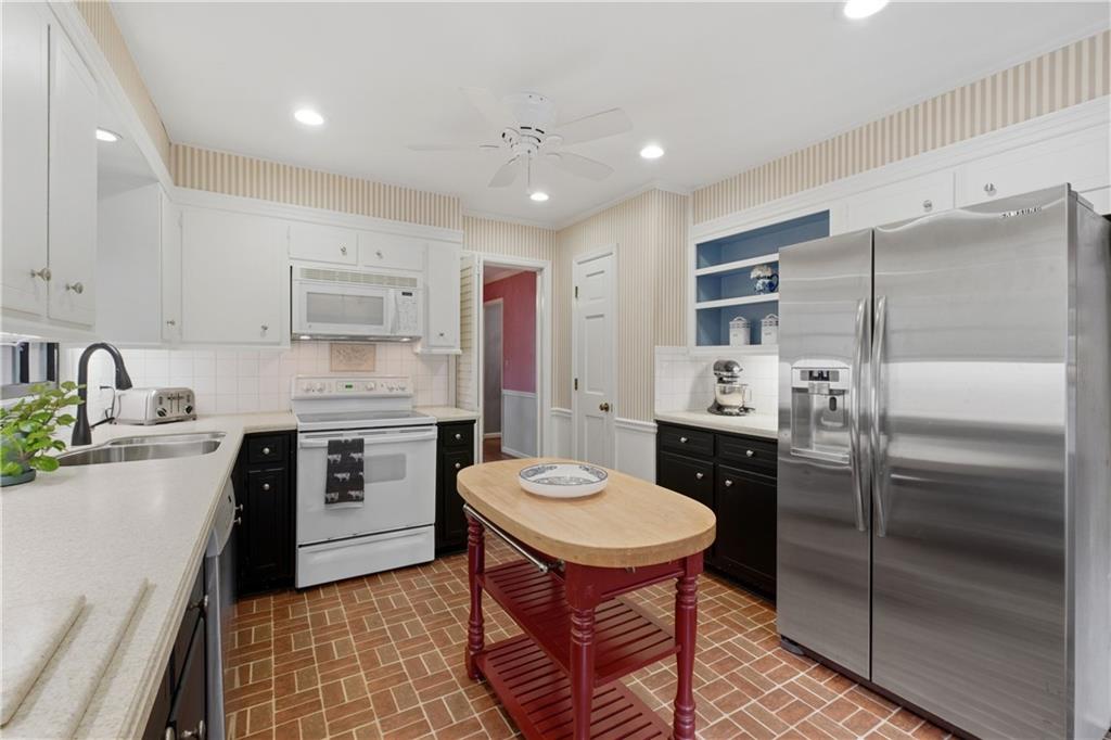 7245 Dunhill Terrace Northeast Atlanta, GA 30328 - Photo 12 of 45 a kitchen with a refrigerator a sink a stove a microwave and cabinets