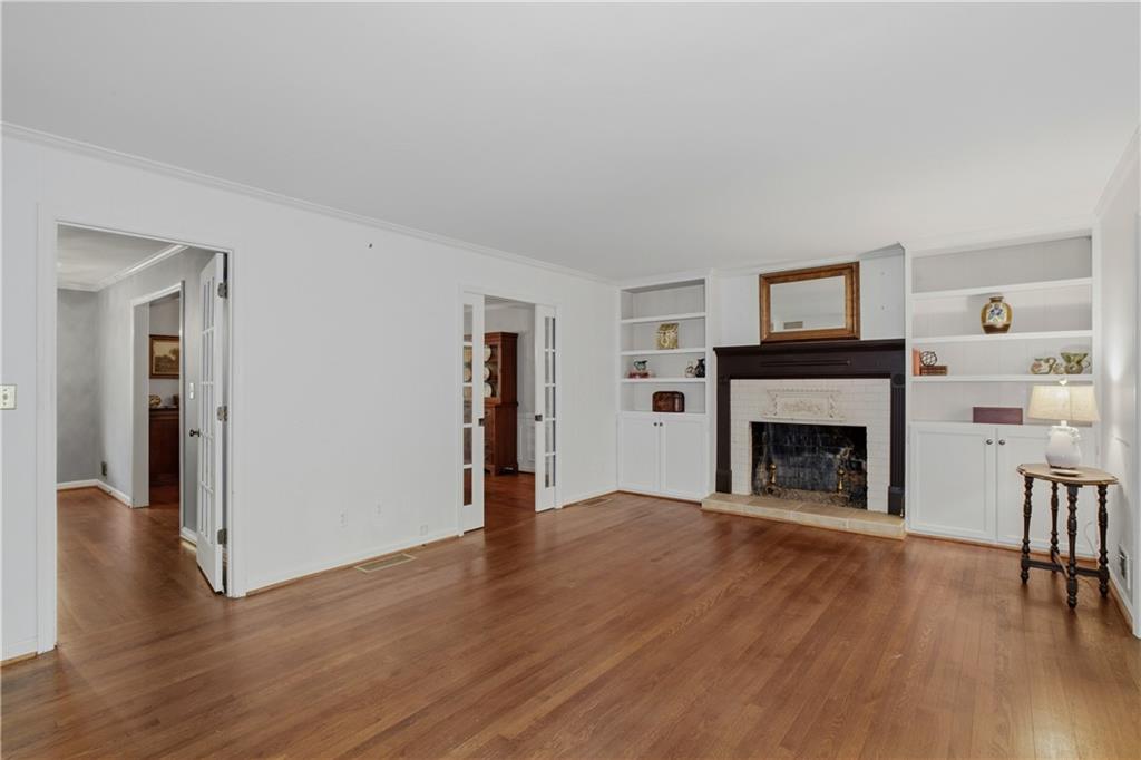 7245 Dunhill Terrace Northeast Atlanta, GA 30328 - Photo 23 of 45 a view of an empty room with wooden floor fireplace and a window