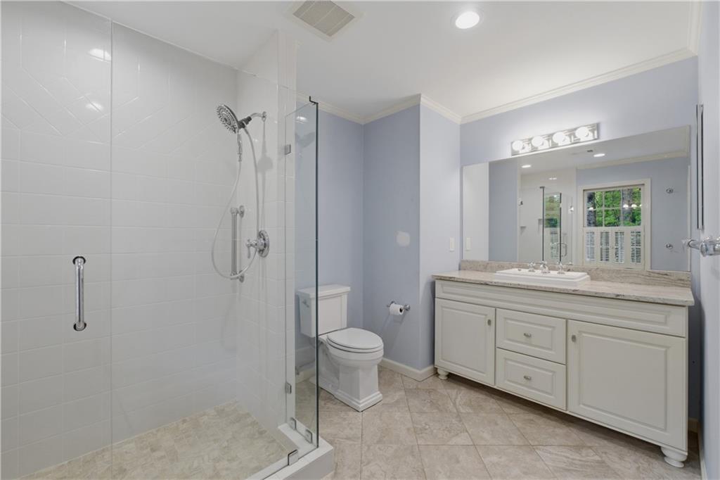 7245 Dunhill Terrace Northeast Atlanta, GA 30328 - Photo 29 of 45 a bathroom with a granite countertop sink a toilet and shower