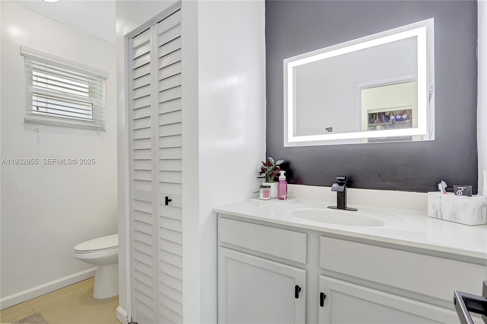 13217 Southwest 257th Terrace Homestead, FL 33032 - Photo 15 of 20 a bathroom with a toilet sink vanity and mirror