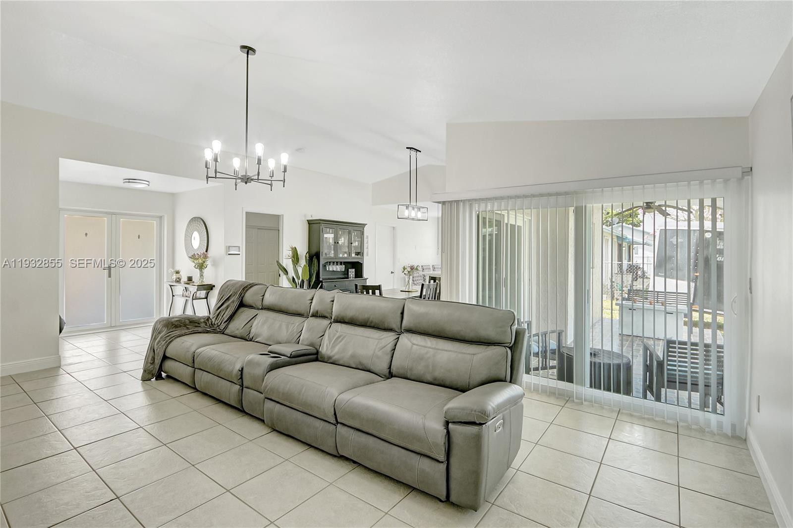 13217 Southwest 257th Terrace Homestead, FL 33032 - Photo 5 of 20 a living room with furniture and a chandelier