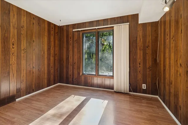 a view of a bedroom with wooden floor and a wooden door