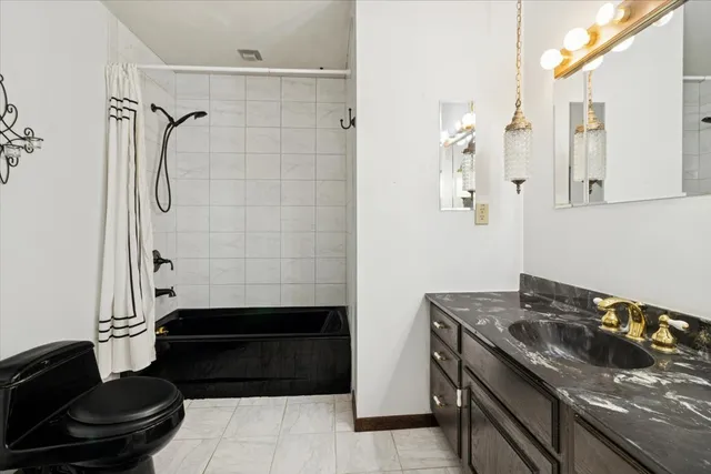 a bathroom with a granite countertop sink a toilet and shower