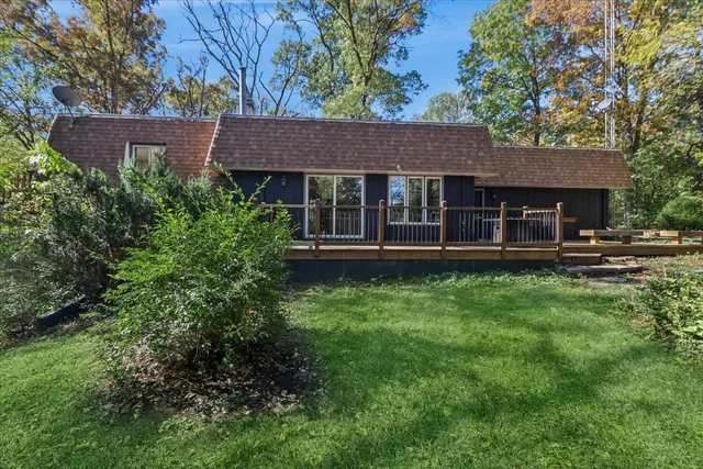 a view of a house with a yard plants and large tree
