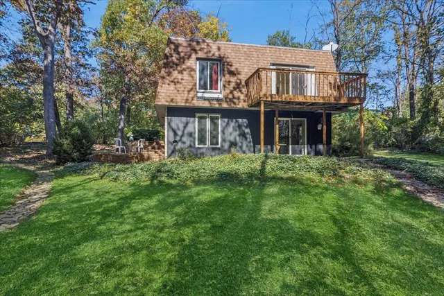 a view of house with a yard and deck