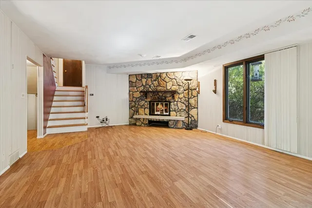 a view of an empty room with a window and fireplace