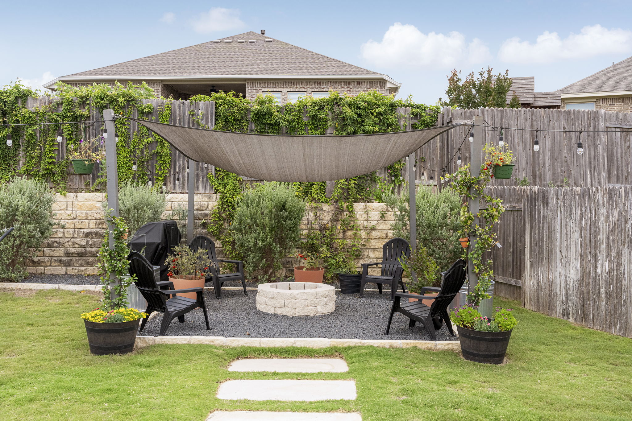 772 Founders Ridge Dripping Springs, TX 78620 - Photo 8 of 40 The backyard lounge area is designed for relaxed outdoor living, complete with thoughtfully installed pavers, a fire pit, and mature landscaping, including Texas sage, oak trees, crepe myrtles, and a jasmine wall.