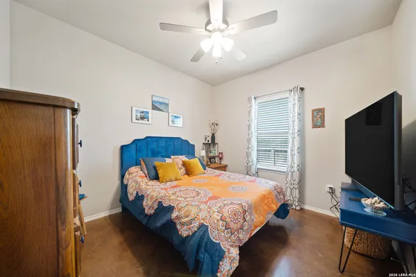 a bedroom with a bed tv and a window