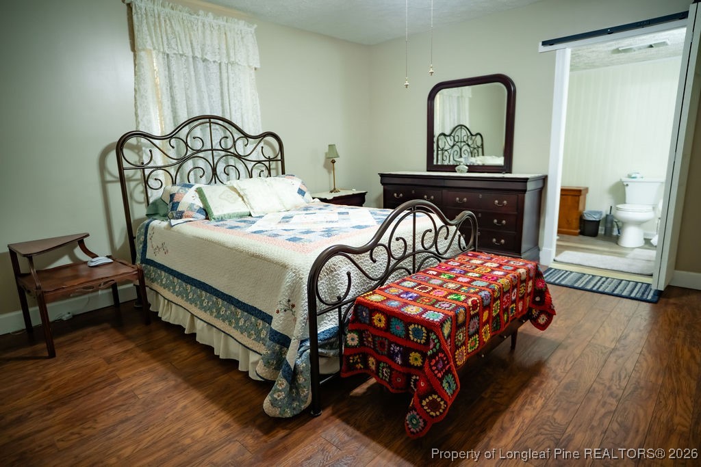 208 Thompson Street Fairmont, NC 28340 - Photo 6 of 19 a bedroom with a bed and wooden floor