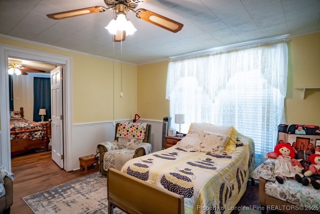 208 Thompson Street Fairmont, NC 28340 - Photo 8 of 19 a bedroom with a bed and wooden floor
