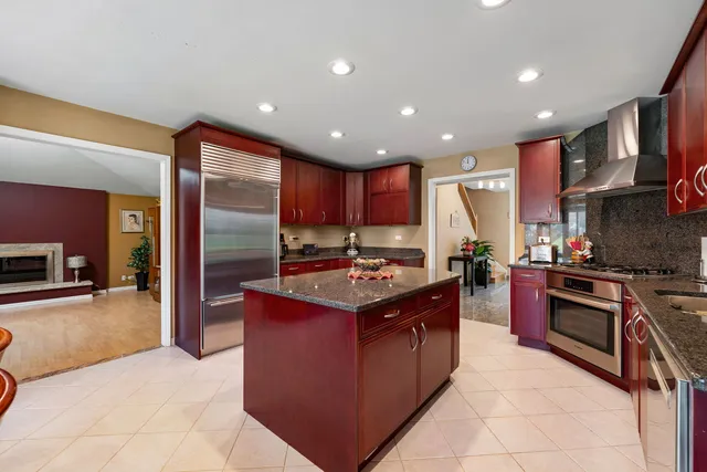a kitchen with kitchen island stainless steel appliances a sink stove and refrigerator