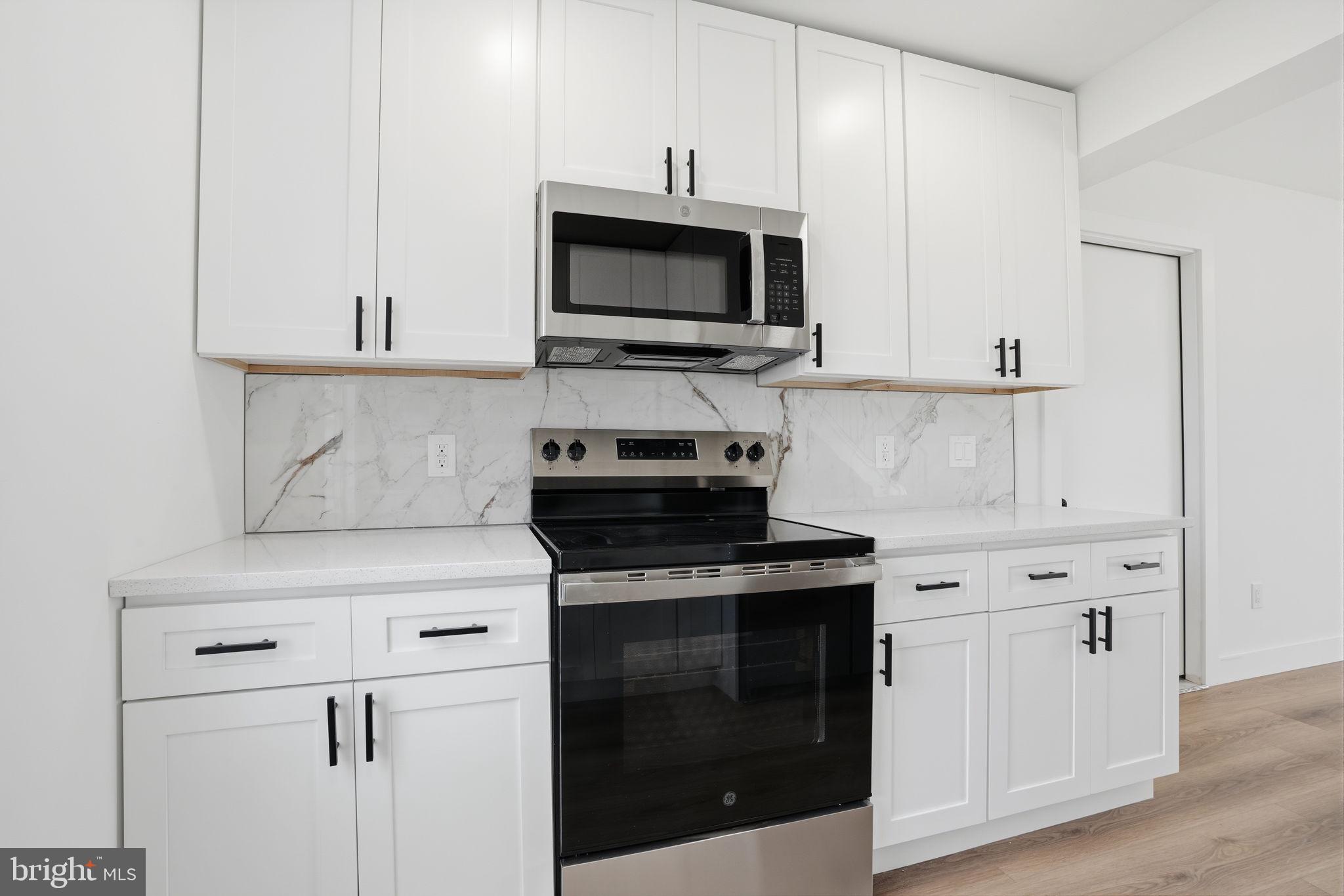 14 Inlet Road Levittown, PA 19057 - Photo 11 of 31 a kitchen with stainless steel appliances granite countertop white cabinets and black stove top oven with granite countertops