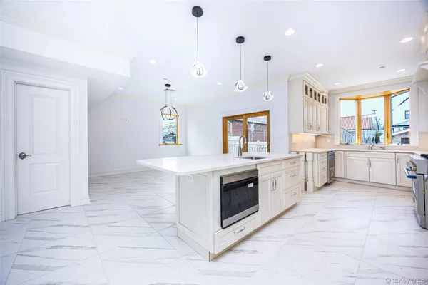 a large white kitchen with a stove a sink and a refrigerator