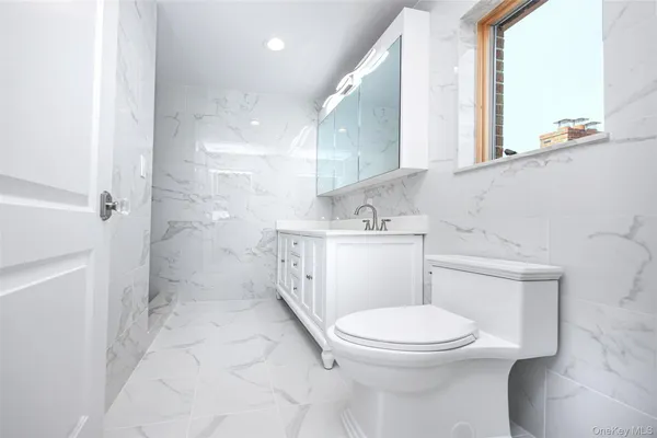 a white toilet sitting next to a bathroom sink