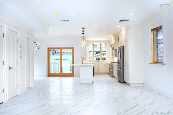 a view of a kitchen with refrigerator and wooden floor