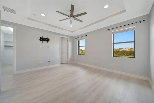 an empty room with windows and fan