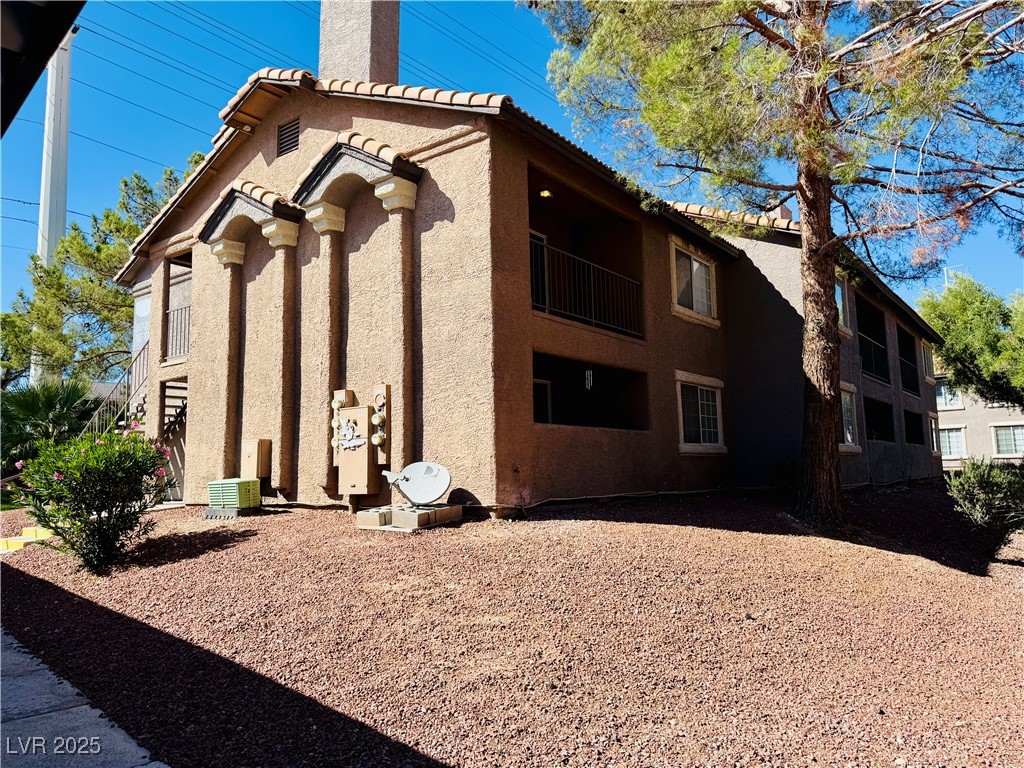 2750 South Durango Drive, Unit 2010 Las Vegas, NV 89117 - Photo 1 of 31 View of home's exterior featuring a tile roof, stucco siding, a chimney, and a balcony