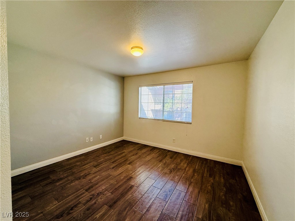2750 South Durango Drive, Unit 2010 Las Vegas, NV 89117 - Photo 12 of 31 Unfurnished room featuring dark wood-style flooring and a textured ceiling