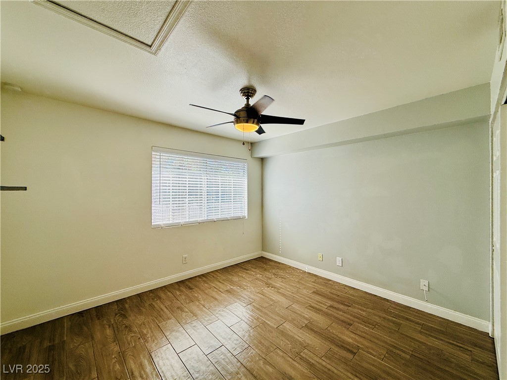 2750 South Durango Drive, Unit 2010 Las Vegas, NV 89117 - Photo 16 of 31 Empty room featuring wood finished floors, a textured ceiling, and ceiling fan
