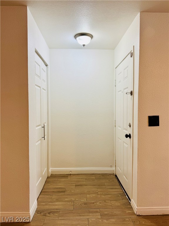 2750 South Durango Drive, Unit 2010 Las Vegas, NV 89117 - Photo 4 of 31 Corridor with a textured wall, light wood-style floors, and a textured ceiling