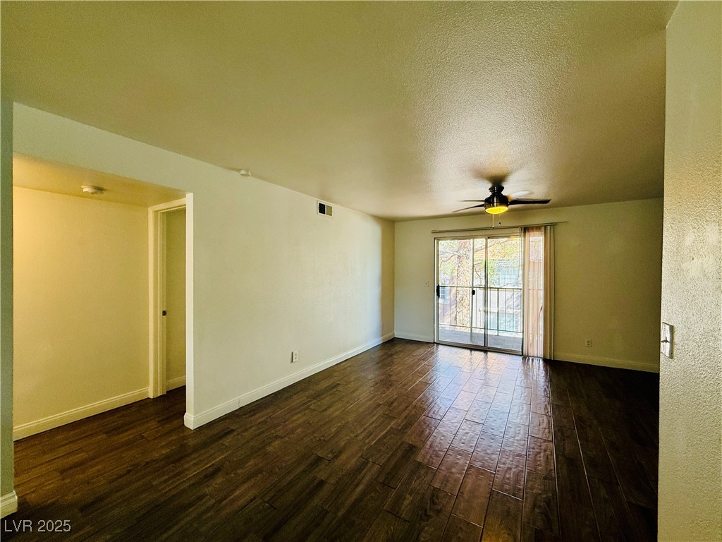 2750 South Durango Drive, Unit 2010 Las Vegas, NV 89117 - Photo 5 of 31 Unfurnished room with dark wood-style flooring, a textured ceiling, and ceiling fan