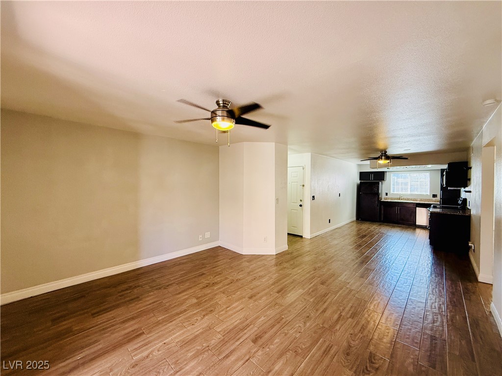 2750 South Durango Drive, Unit 2010 Las Vegas, NV 89117 - Photo 7 of 31 Unfurnished living room featuring a ceiling fan, dark wood-style floors, and a textured ceiling