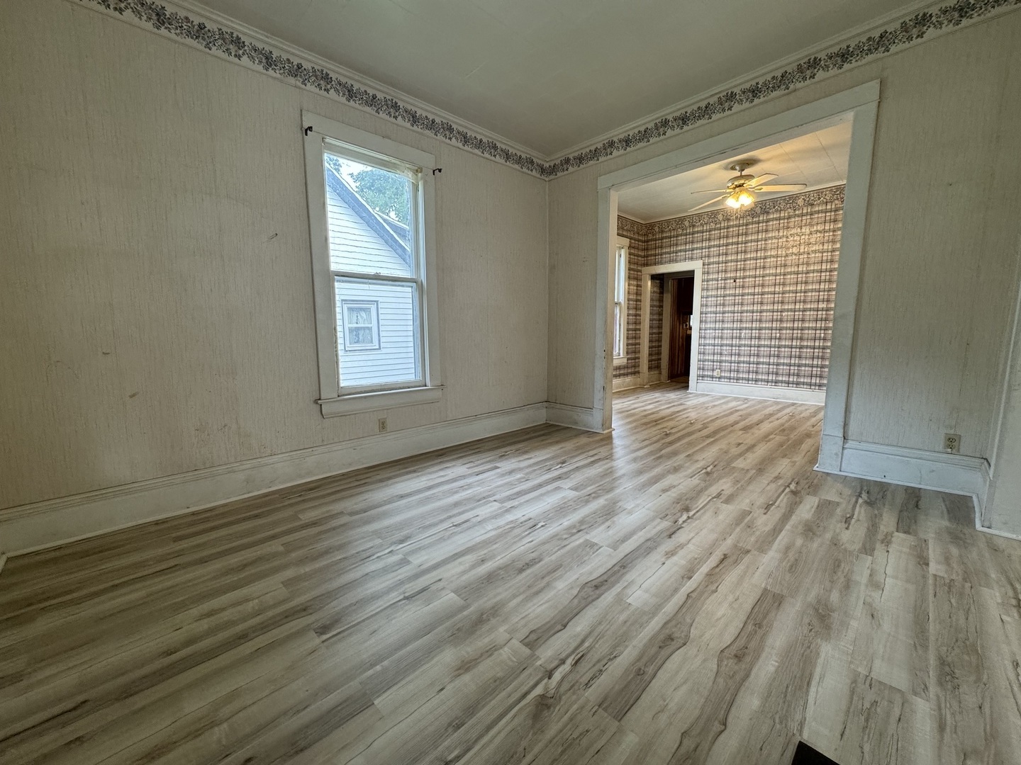 734 West Henry Street Pontiac, IL 61764 - Photo 3 of 17 a view of an empty room with wooden floor and a window