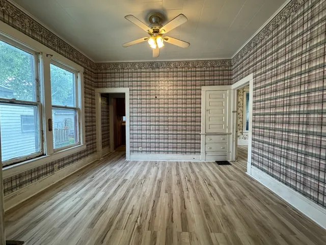 a view of a livingroom with wooden floor and a ceiling fan