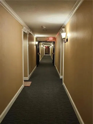 an empty room with wooden floor mirror and windows