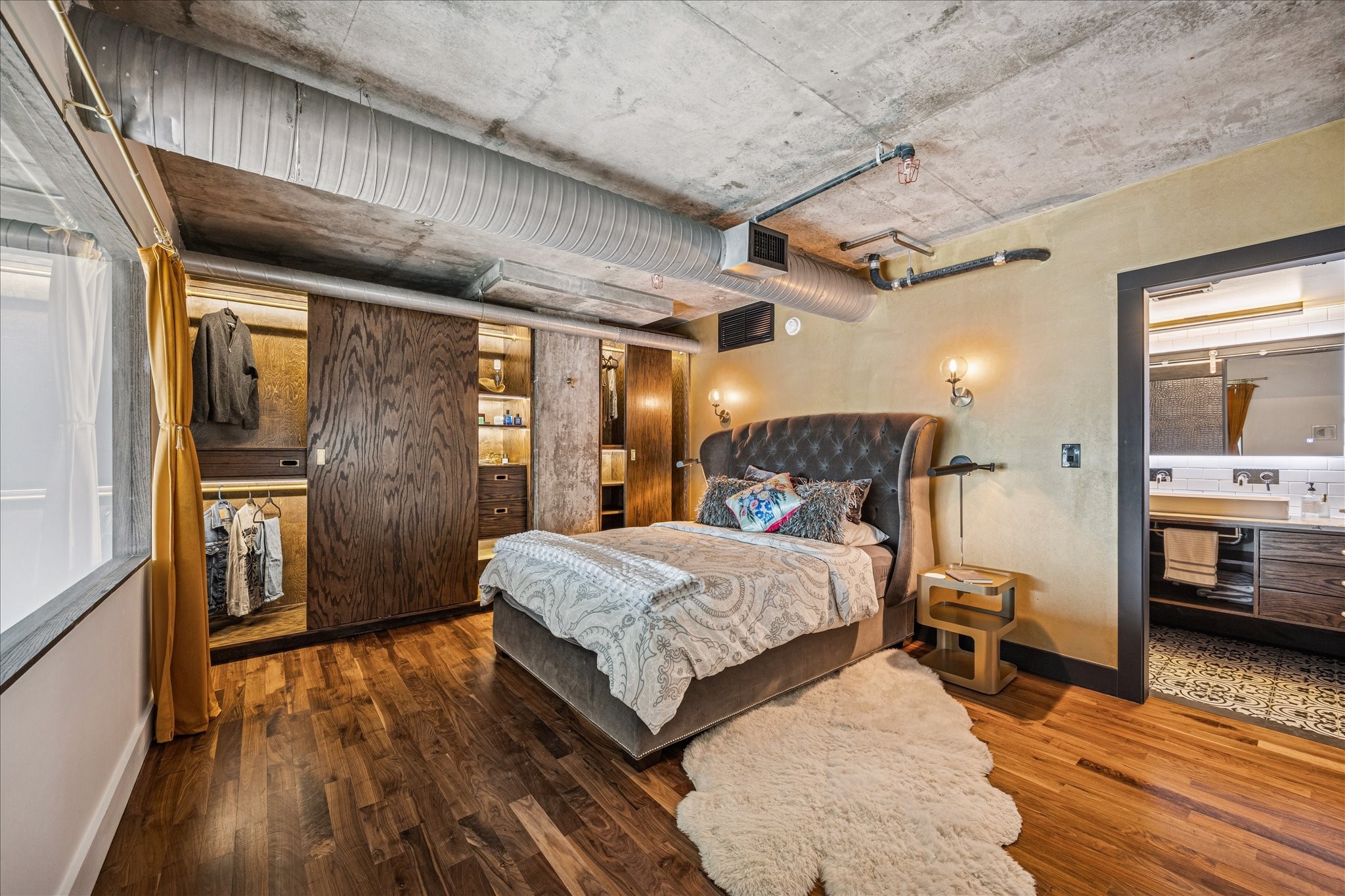 2000 Bagby Street, Unit 5400 Houston, TX 77002 - Photo 21 of 47 Primary bedroom featuring walnut flooring, ample space for a king bed, and a custom LED-lit armoire.