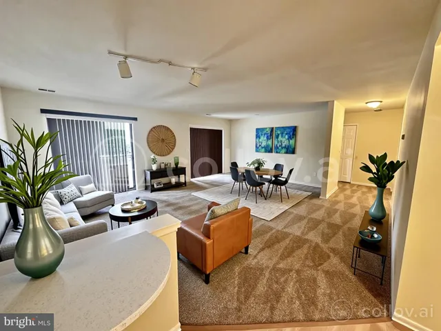 a living room with furniture potted plant and a wooden floor