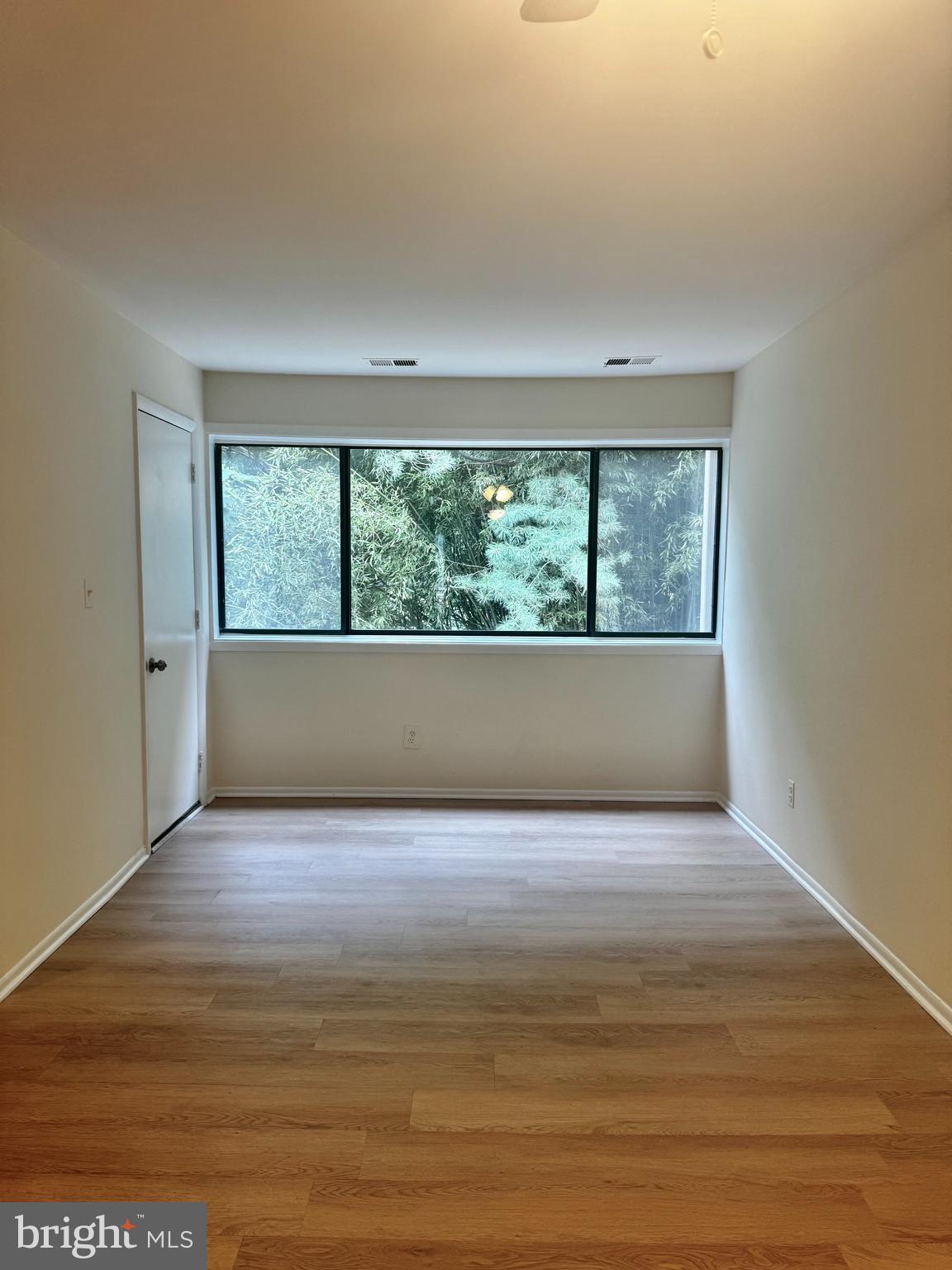 8 Winners Circle, Unit 2B Owings Mills, MD 21117 - Photo 6 of 14 a view of an empty room with wooden floor and a window