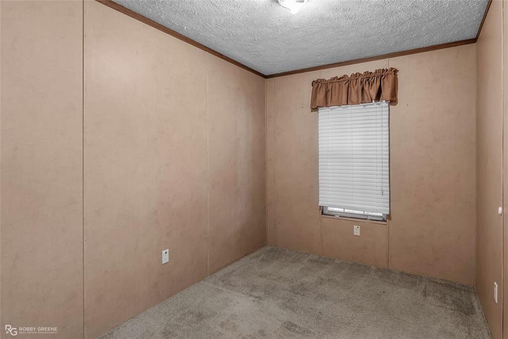 209 Addison Road Mansfield, LA 71052 - Photo 17 of 25 Empty room featuring ornamental molding, carpet, a textured ceiling, and a decorative wall