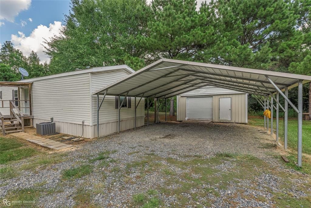 209 Addison Road Mansfield, LA 71052 - Photo 3 of 25 View of car parking with a shed, a detached carport, and gravel driveway