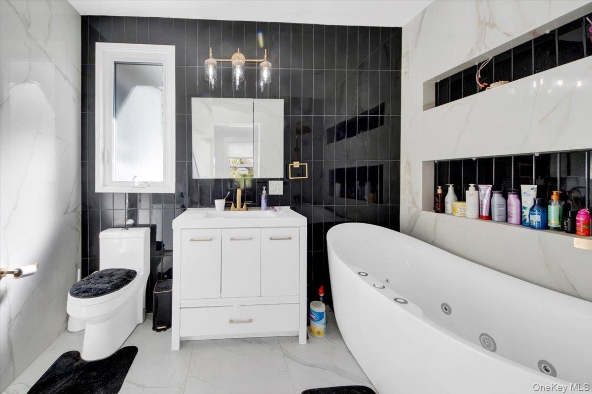 1 Slocum Street New Rochelle, NY 10801 - Photo 29 of 49 a bathroom with a bathtub sink a toilet and a mirror