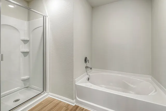 a bathroom with a tub sink double vanity and a mirror
