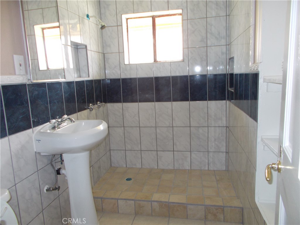 8343 Trey Avenue, Unit A Riverside, CA 92503 - Photo 12 of 17 a bathroom with a sink a window and shower