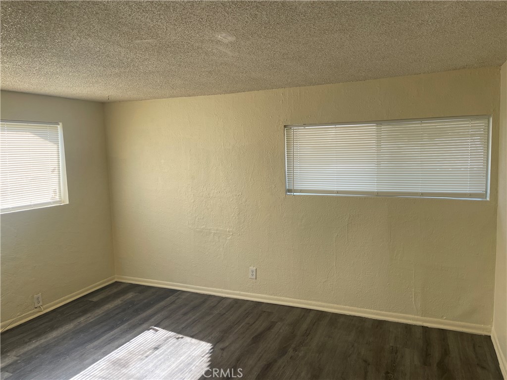 8343 Trey Avenue, Unit A Riverside, CA 92503 - Photo 4 of 17 an empty room with wooden floor and windows