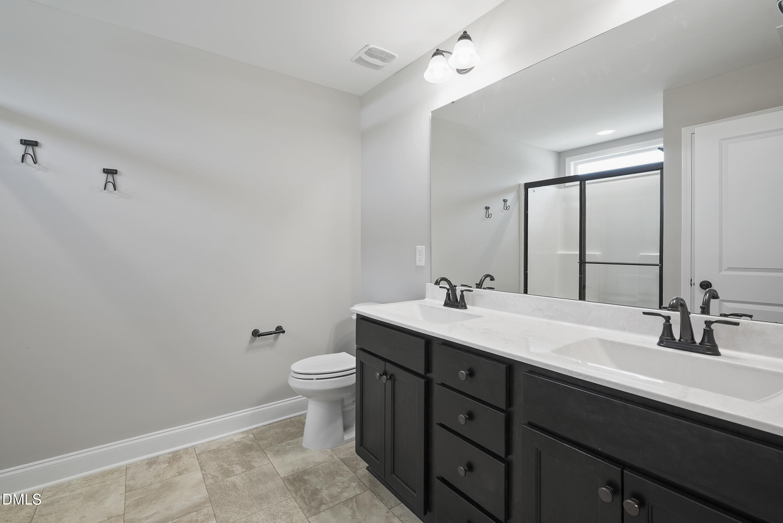 262 Day Lily Street Selma, NC 27576 - Photo 27 of 39 a bathroom with a double vanity sink toilet and mirror