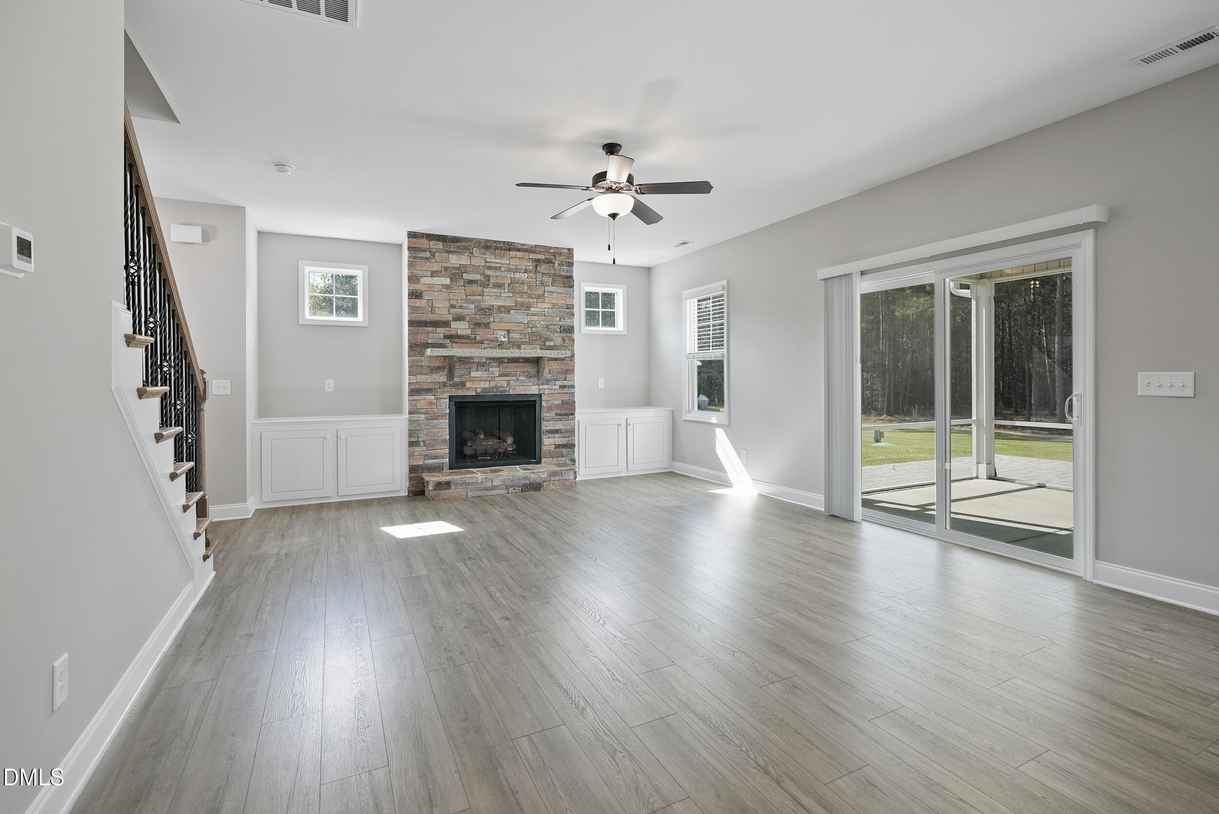 262 Day Lily Street Selma, NC 27576 - Photo 5 of 39 an empty room with wooden floor fireplace and windows