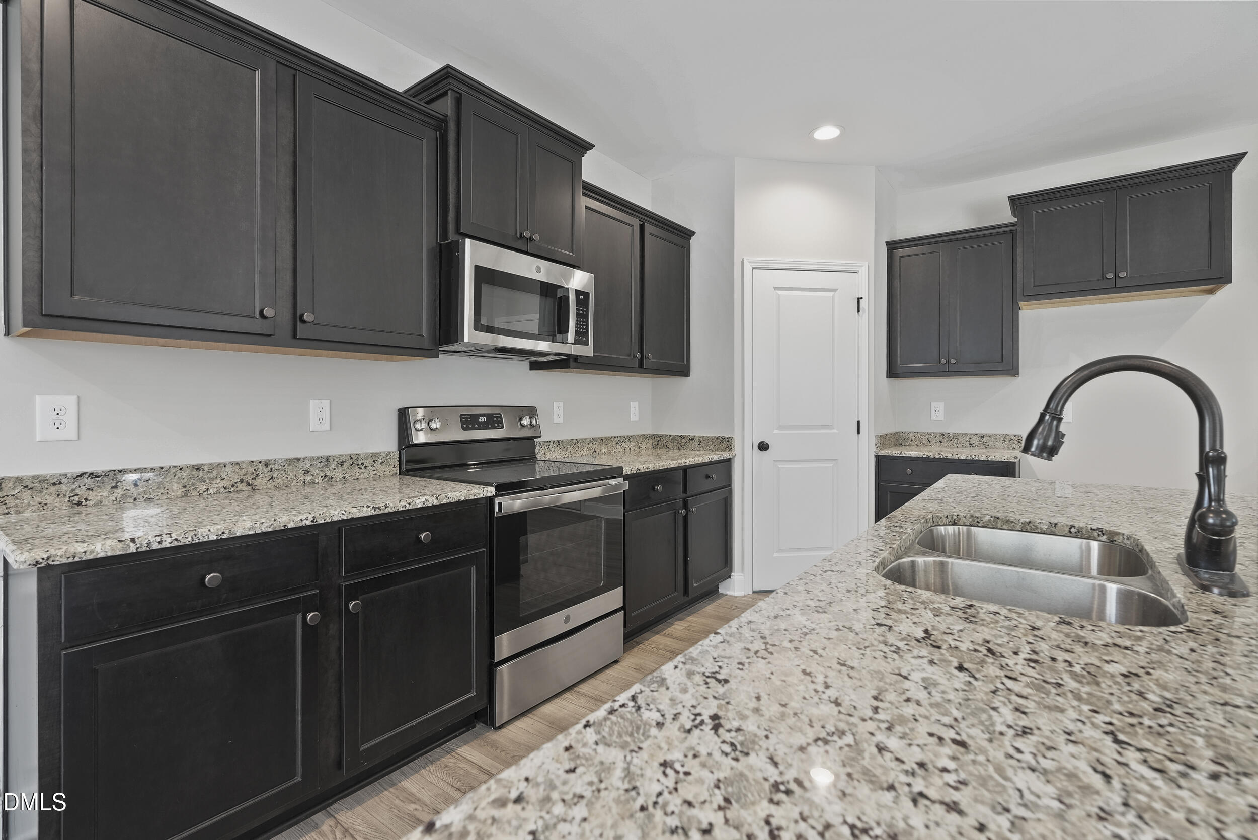 262 Day Lily Street Selma, NC 27576 - Photo 8 of 39 a kitchen with stainless steel appliances granite countertop a stove a sink dishwasher and a microwave oven with wooden cabinets