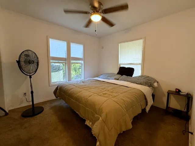 a bedroom with a bed a chandelier and a window